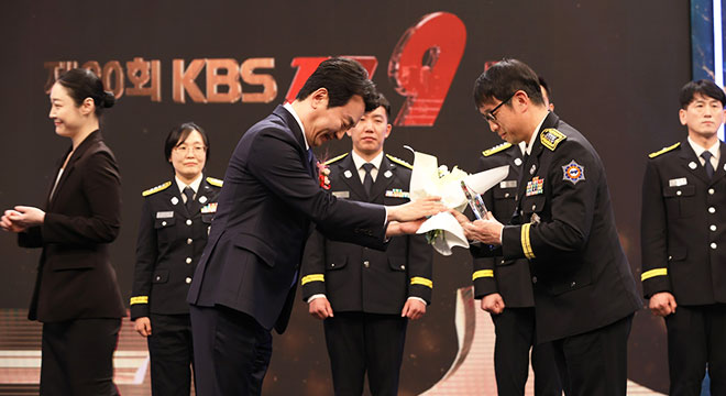 본상 수상 꽃다발과 수상트로피를 전달 받고 있는 모습